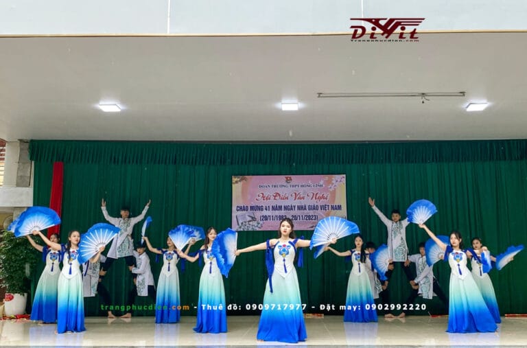 Nhóm múa với váy xanh trắng và đạo cụ hoa